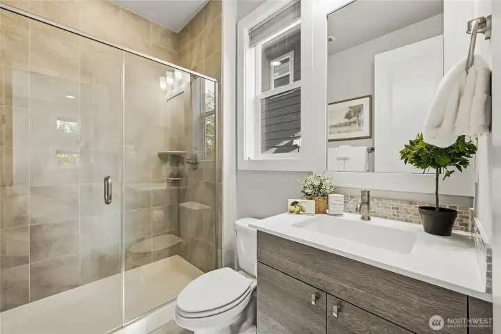 The main-floor bath continues the home’s elevated design aesthetic with sleek finishes and thoughtful detail.
