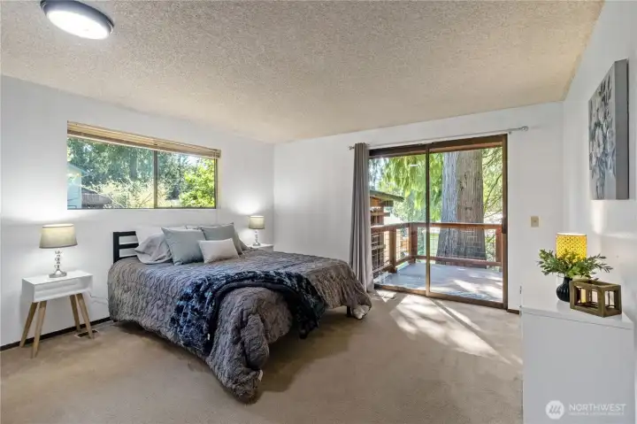 Spacious main floor primary bedroom with deck access