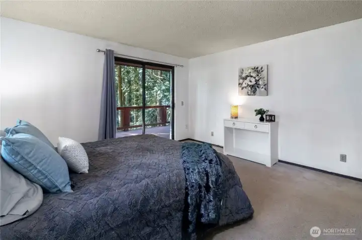Large primary bedroom with peaceful wooded view