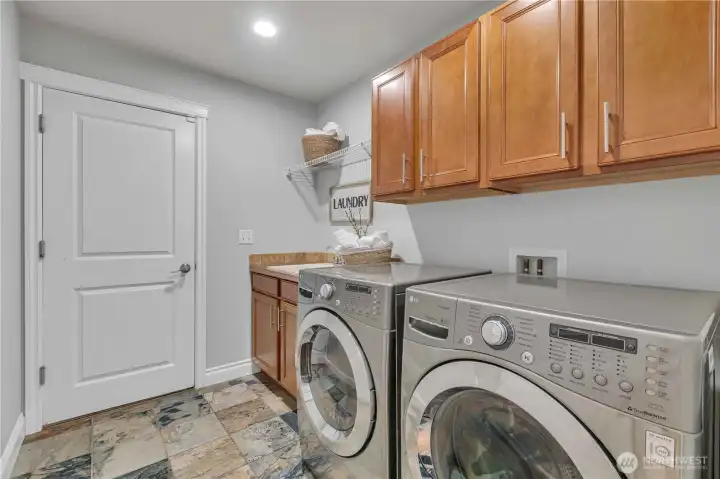 Main-Floor Laundry (Washer & Dryer Stay) with Door Leading to the 3-Car Garage