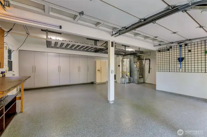 Spacious garage with work bench, overhead and wall storage