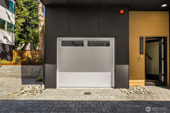 Modern attached garage with sleek glass-paneled door and a clean, welcoming entryway. Modern attached garage with sleek glass-paneled door and a clean, welcoming entryway.