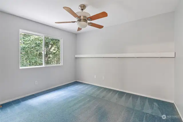 One of the 4 bedrooms upstairs w/ceiling fan and view of backyard.