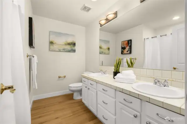 Upper-level hallway bathroom with dual sinks and full bath.