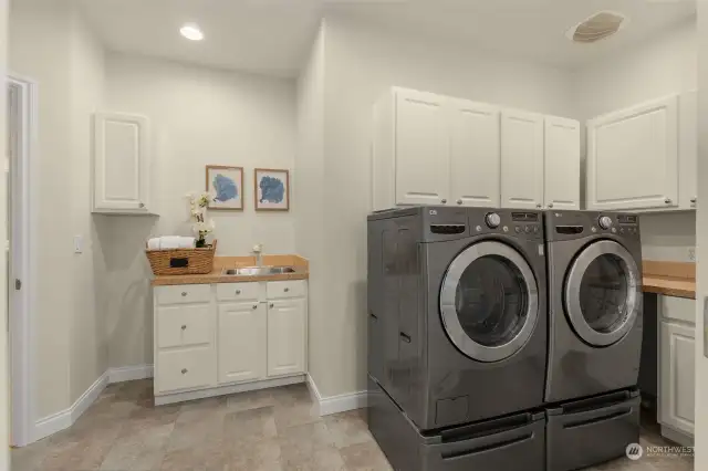 Convenient laundry and mudroom with a sink located just off the garage entry.