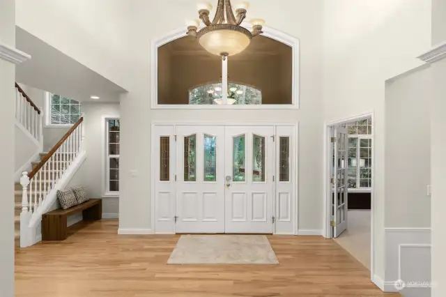 impressive double doors welcome you to a space of soaring ceilings, pristine hardwood floors, and abundant natural light.