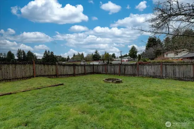 Spacious fenced yard with firepit.