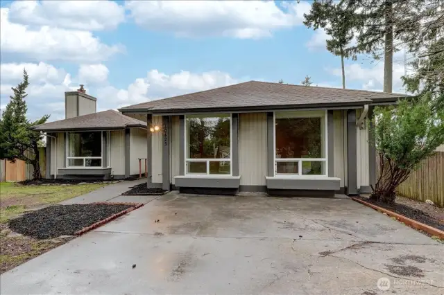 Front driveway area with the front section converted to living space. 4th bedroom on the left and bonus/rec room  on the right with an outside entrance on the right side of the home.