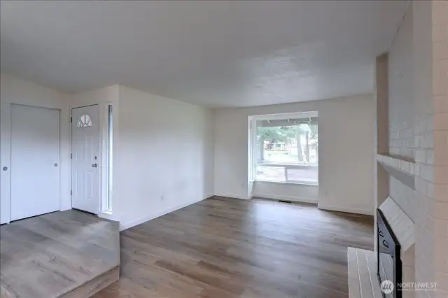 Living room - note newer vinyl windows and new flooring, millwork and paint throughout.