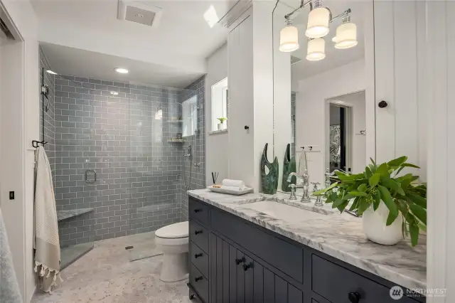 The primary bath has a gorgeous walk in shower, marble flooring and beautiful cabinetry!
