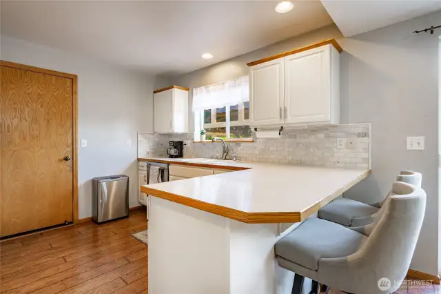 Kitchen featuers SS appliances, a breakfast bar and window looking out to the backyard.  Access to garage off kitchen