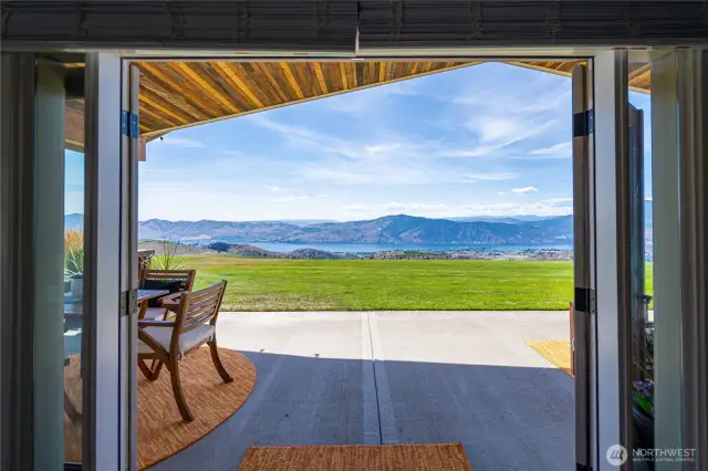 Double doors open to patio and manicured lawn