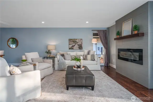 The living room features a sleek, modern fireplace.