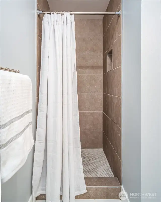 A walk-in shower with beautiful tile work completes the space.