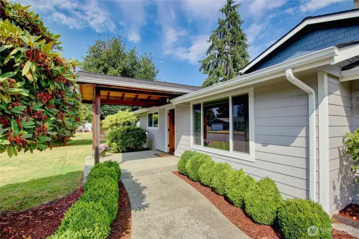 Front walkway to covered porch lined with boxwood.