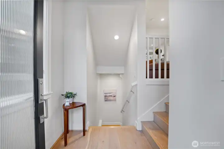The entry welcomes you with access to the garage (downstairs) and a convenient bedroom tucked just beyond.  The stairs lead gracefully upward to the main living area, where light and comfort await.