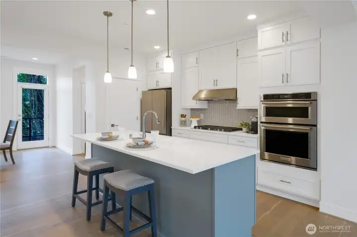 A large blue center island anchors the space, offering both seating and a stylish focal point.