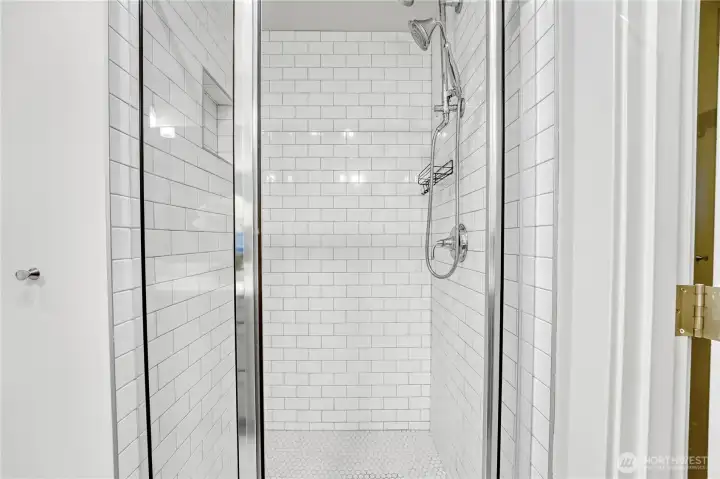 The sleek shower is finished in elegant white metro tile, creating a crisp, timeless look.