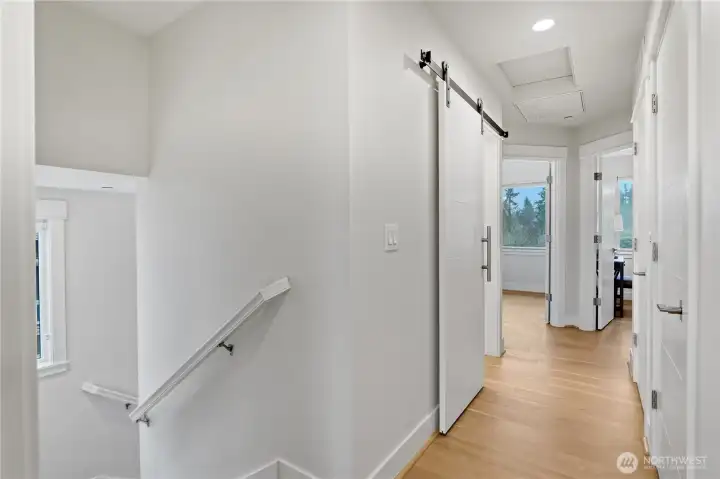 From the entry to the primary suite, the upstairs hallway offers a bright, open view of the home’s upper level.