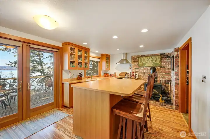 Kitchen with large island with storage on both sides, french doors to the deck, free standing gas stove.  Dishes, silverware, pots and pans, serving platters. Everything stays with the home.