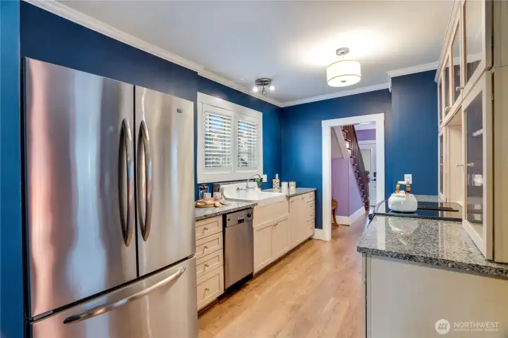 The kitchen includes a complete set of appliances: a Jenn Air oven with an induction range, a compact dishwasher, and the refrigerator/freezer.
