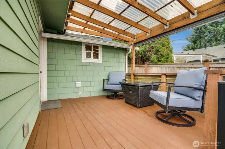 The covered deck is ready for outdoor meals in summer, or cups of coffee on rainy days.