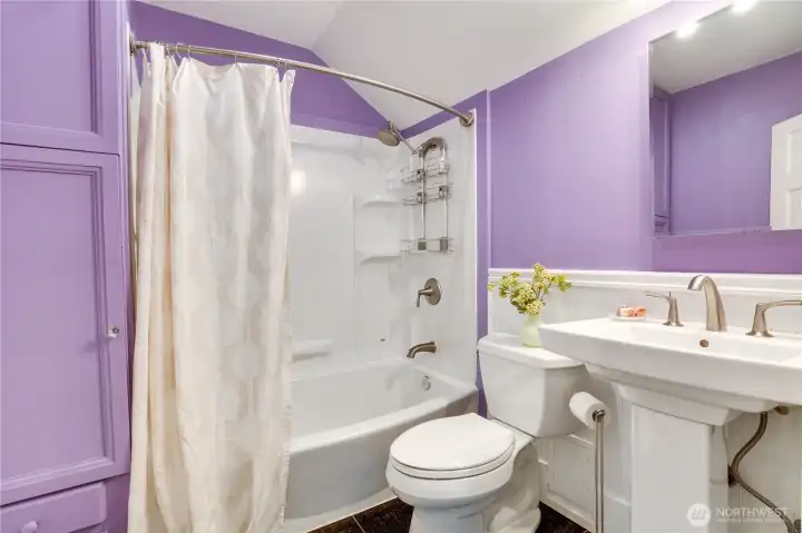 This full bath set at the top of the stairs within easy reach of the bedrooms. A linen closet at the end of the shower-bath offers good storage.