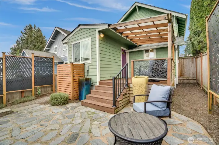 Father Nature Landscapes created a tranquil, private space out back with a flagstone patio, privacy screens, and a fence around the compressor. A gravel walkway flanks the north side of the home with a gate to the front yard. The path also leads to garage's back door.