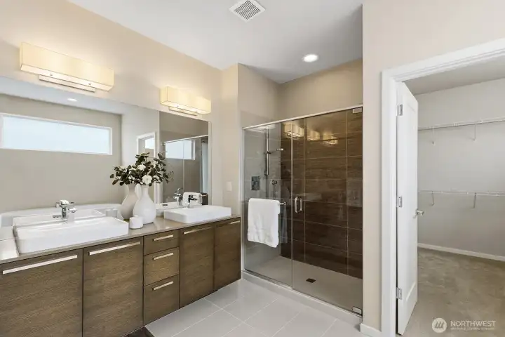 Closer look at the main floor primary ensuite shower, double sinks and large walk-in closet.