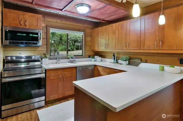 Creamy white Wilsonart Solid Surface countertops and new stainless appliances complement the kitchen