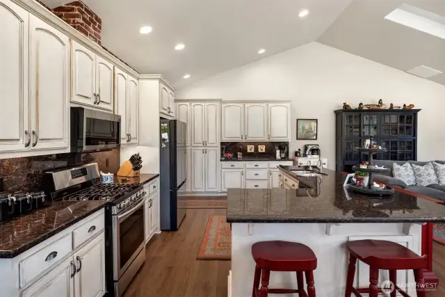 Open concept kitchen with custom painted cabinets and large granite island.