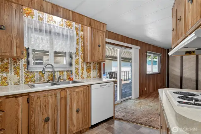 Kitchen has large window and adjoining sliding door out to covered patio.