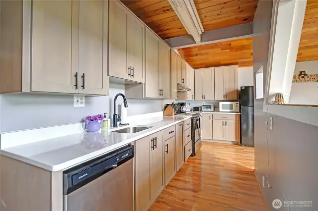 Beautifully updated kitchen featuring new countertops and cabinetry, sleek stainless steel appliances, and abundant storage.