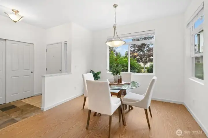 Charming dining area with large windows overlooking a beautiful landscape, perfect for enjoying natural light and seasonal views.