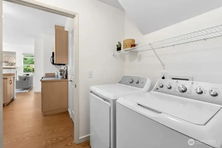 Laundry room with brand-new GE washer and dryer plus overhead shelving for household essentials.