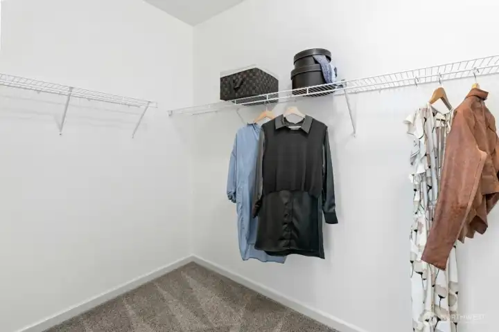Spacious primary walk-in closet with built-in shelving, ready for your wardrobe today and the custom closet of your dreams tomorrow.