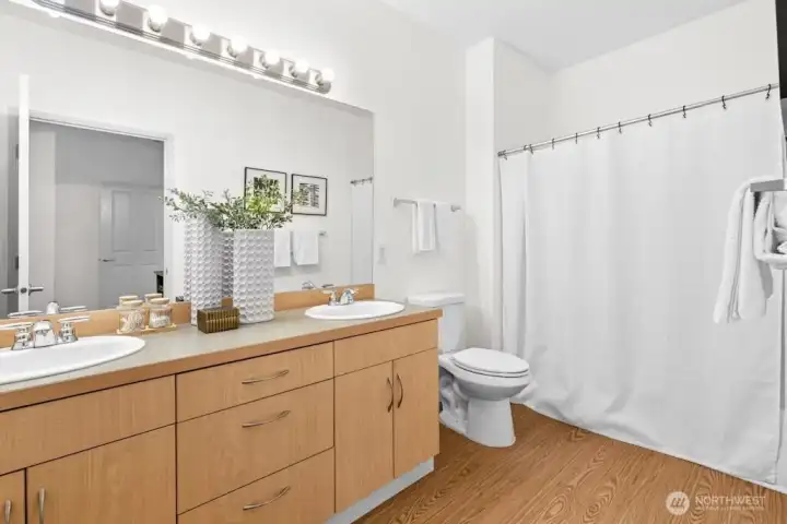 Primary ensuite bathroom with dual sinks, ample counter space, and a full tub and shower.