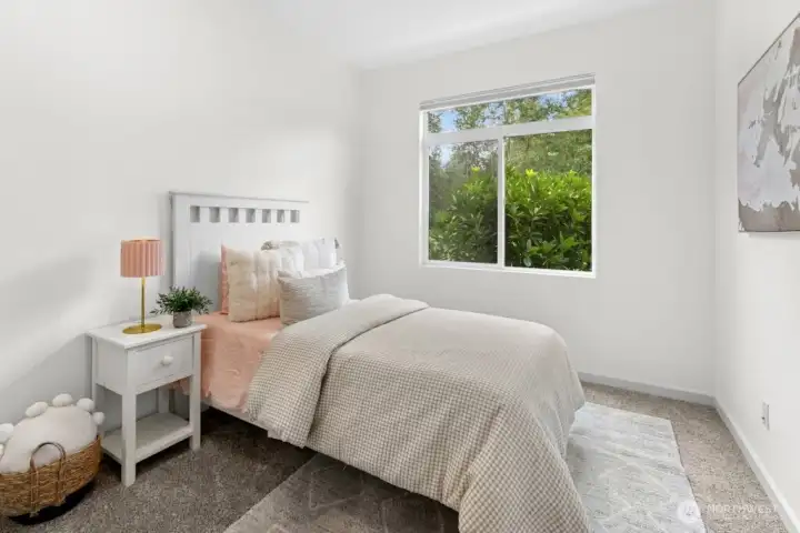 First bedroom with calming greenbelt views, conveniently located across from the hall linen closet.
