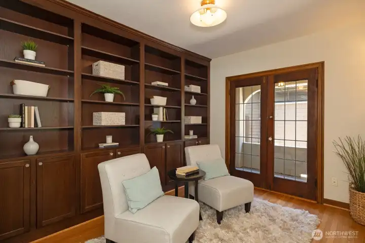 Adjacent den with beautiful library shelving & French doors to the covered front porch.
