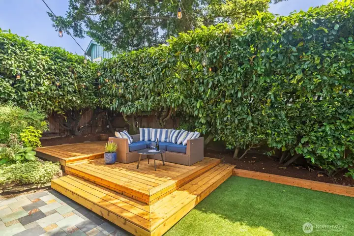 The new decks forms a private sitting area nestled against lush greenery.