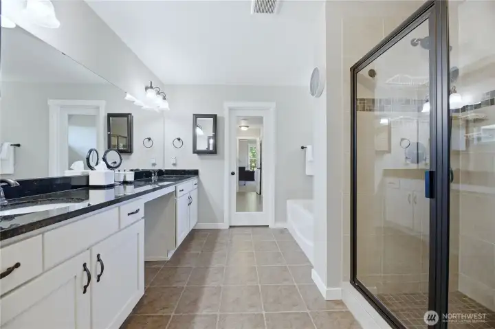 Primary bathroom features a soaking tub, shower, dual sinks, and private water closet, plus two walk-in closets outfitted with premium California Closet systems.