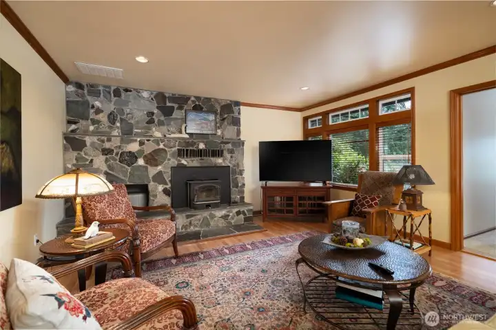 Main flor living room with wood insert fireplace, rock surround and wood flooring. Main flor living room with wood insert fireplace, rock surround and wood flooring.