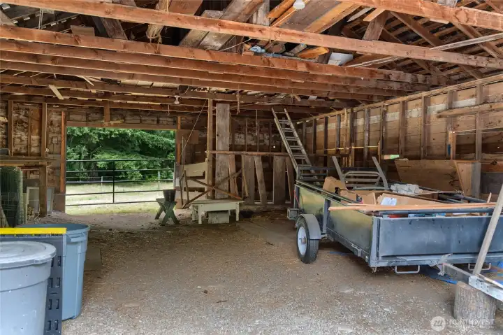 Inside of the barn looking to the West pasture. Additional covered area along North side of structure to keep horses out of the weather. Inside of the barn looking to the West pasture. Additional covered area along North side of structure to keep horses out of the weather.