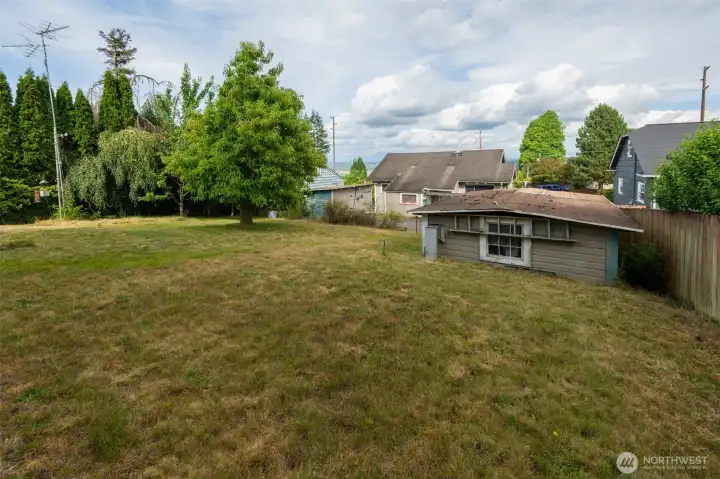back corner of lot facing back exterior of house (south side)/ garage