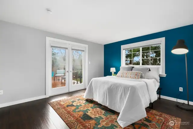 Primary bedroom w/ private french doors leading to deck area