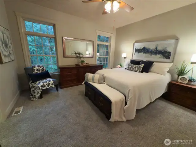 Primary bedroom w/ beautiful view of the peaceful forest.