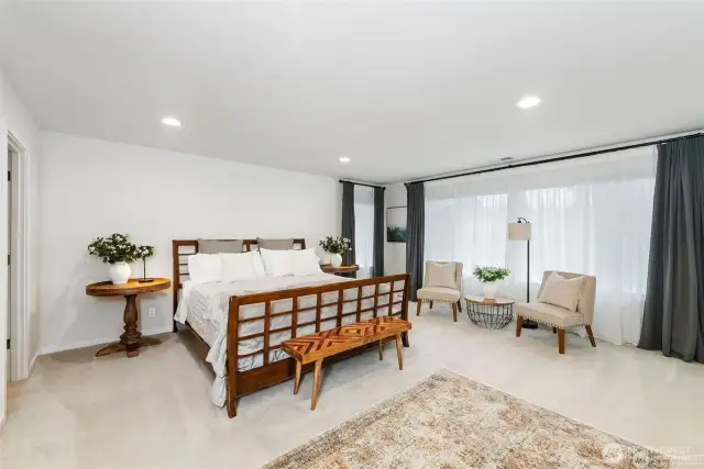 The luxurious primary suite offers a serene retreat. It includes a sitting area, a spa-like en-suite bathroom with a soaking tub and a shower, and two expansive walk-in closets with custom organizers....