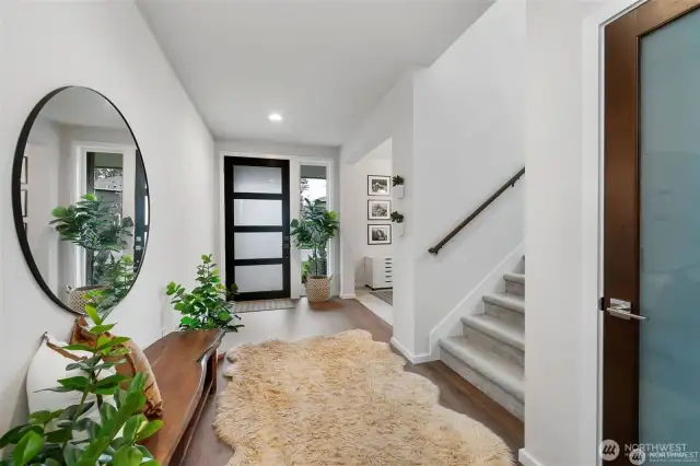 Stepping through the inviting entryway, you find yourself in a spacious, light-filled foyer. Large windows invite in natural light, creating an airy atmosphere.