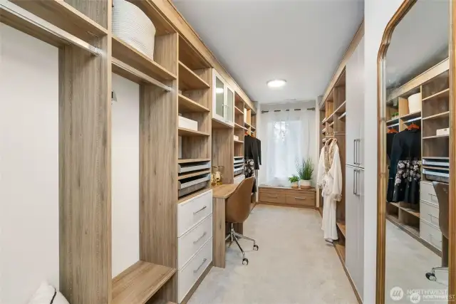 As you step into the first primary closet of this exquisite home, you'll be immediately struck by its spaciousness and thoughtful design. This closet is not just a place to store clothes; it's a sanctuary for fashion enthusiasts and those who appreciate organization and style. The closet is generously sized, offering ample room for even the most extensive wardrobe collection. This space creates a serene atmosphere. Recessed lighting fixtures on the ceiling provide soft, warm illumination, making it easy to appreciate every detail of your clothing collection....