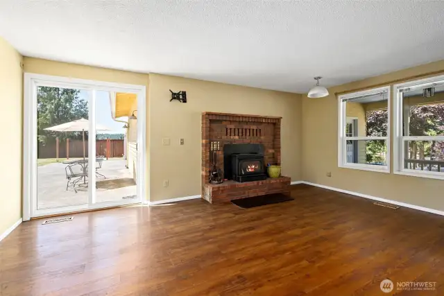 Living area with woodstove and slider that leads to a massive backyard.